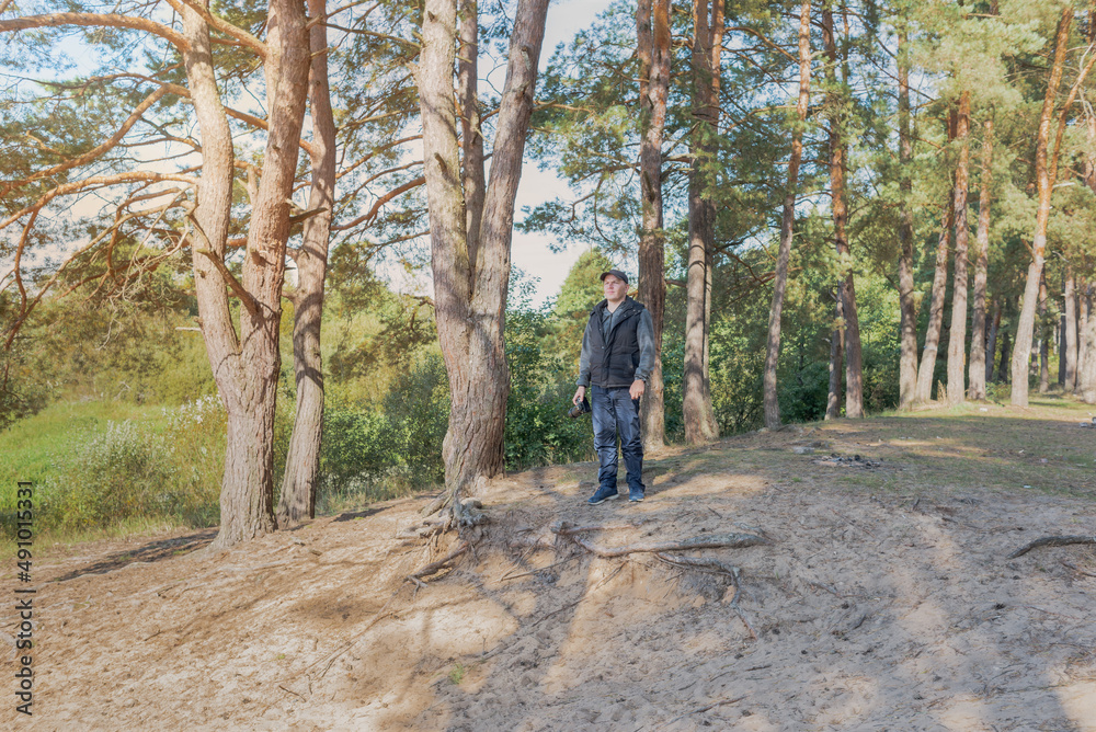 Man nature photographer taking pictures in the forest.