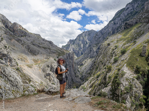 Mujer con mochila y pantalón corto deportista, en la Ruta del Cares desde Poncebos en Asturias, para senderistas amantes de la naturaleza y excursiones de montaña, en el verano de 2020