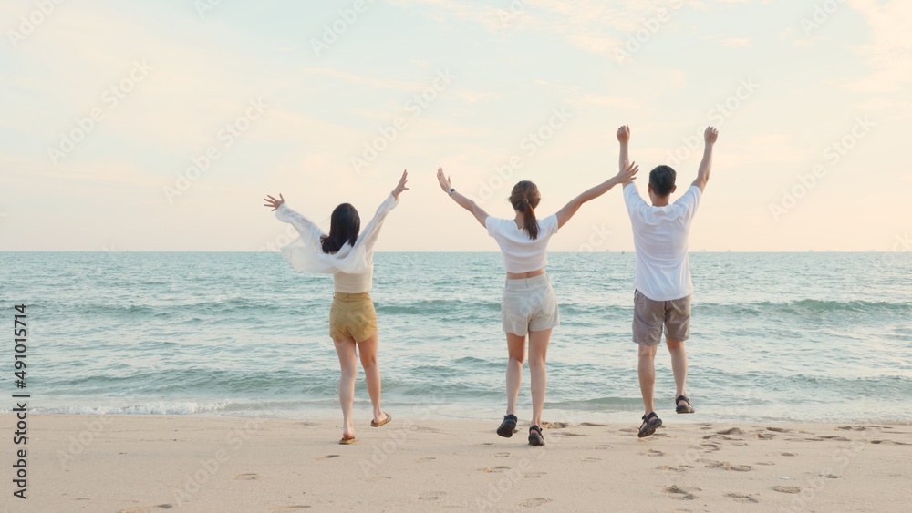 Happy friends holding hands running enjoy life funny and freedom on sand at beach together to sea in holiday vacation time at sunset, Young Asian group woman and man in summer travel, people lifestyle