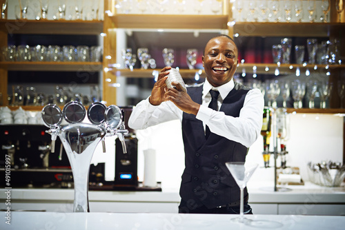 Its time to shake things up in here. Cropped shot of a well-dressed bartender standing behind the counter. photo