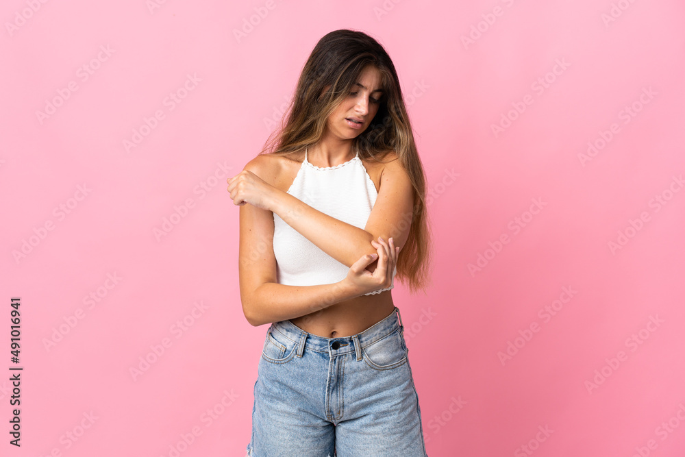 Young caucasian woman isolated on pink background with pain in elbow Young caucasian woman isolated on pink background with pain in elbow