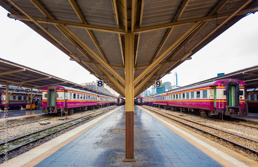 Railway station platform with metal platform roof where passenger trains are parked