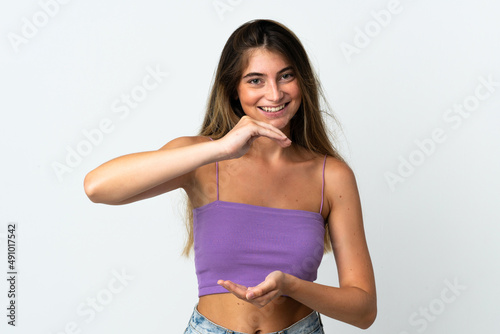 Young caucasian woman isolated  on white background holding copyspace imaginary on the palm to insert an ad © luismolinero
