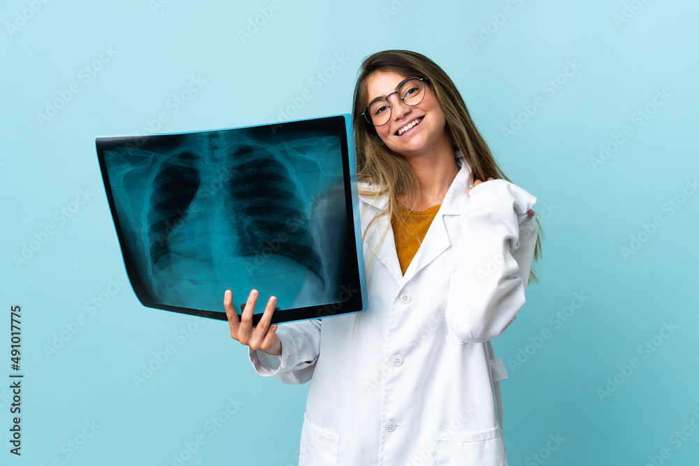 Professional traumatologist isolated on blue background laughing Professional traumatologist isolated on blue background laughing