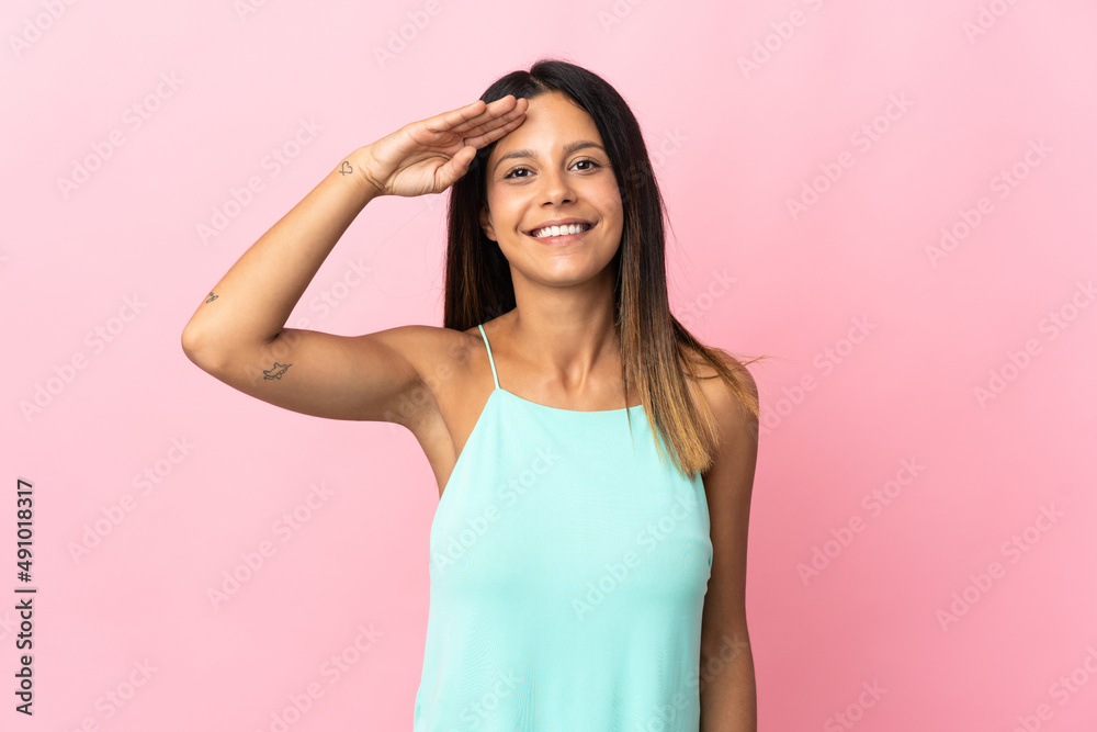 Caucasian girl isolated on pink background saluting with hand with happy expression Caucasian girl isolated on pink background saluting with hand with happy expression