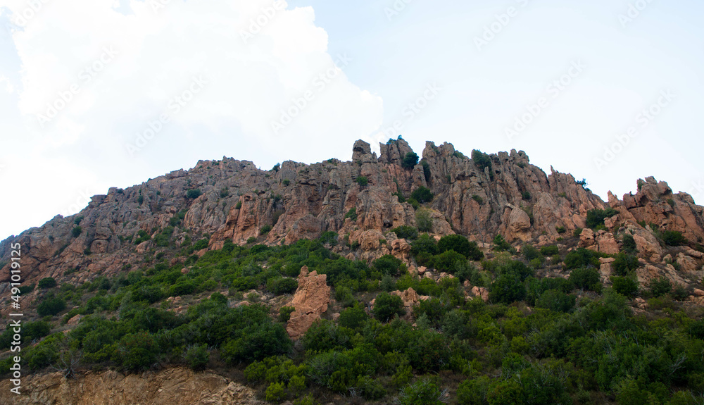 Aerial view of beautiful view of sunlit red mountains in Calanches area on Corsica island, France. Tourism and vacations concept.