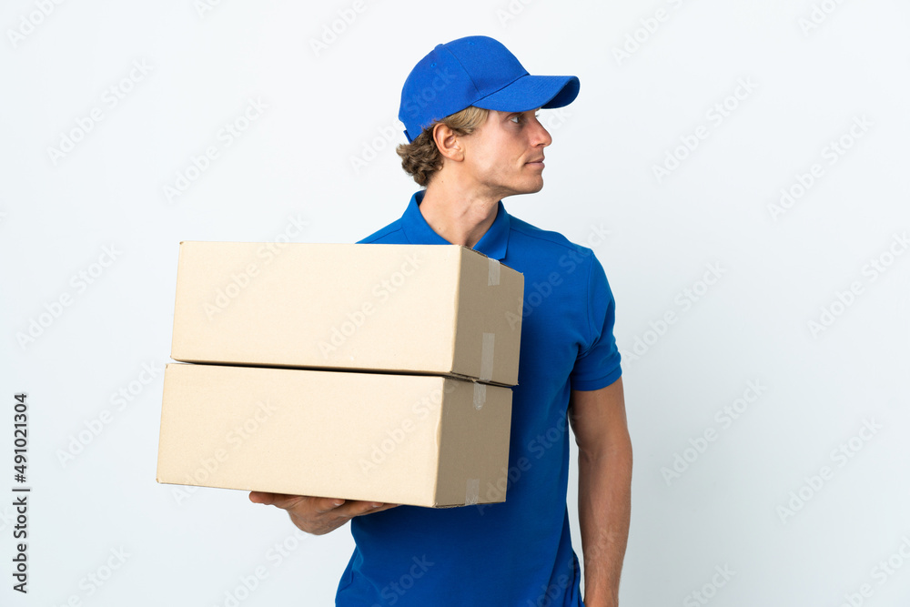 Delivery man over isolated white background looking to the side Delivery man over isolated white background looking to the side