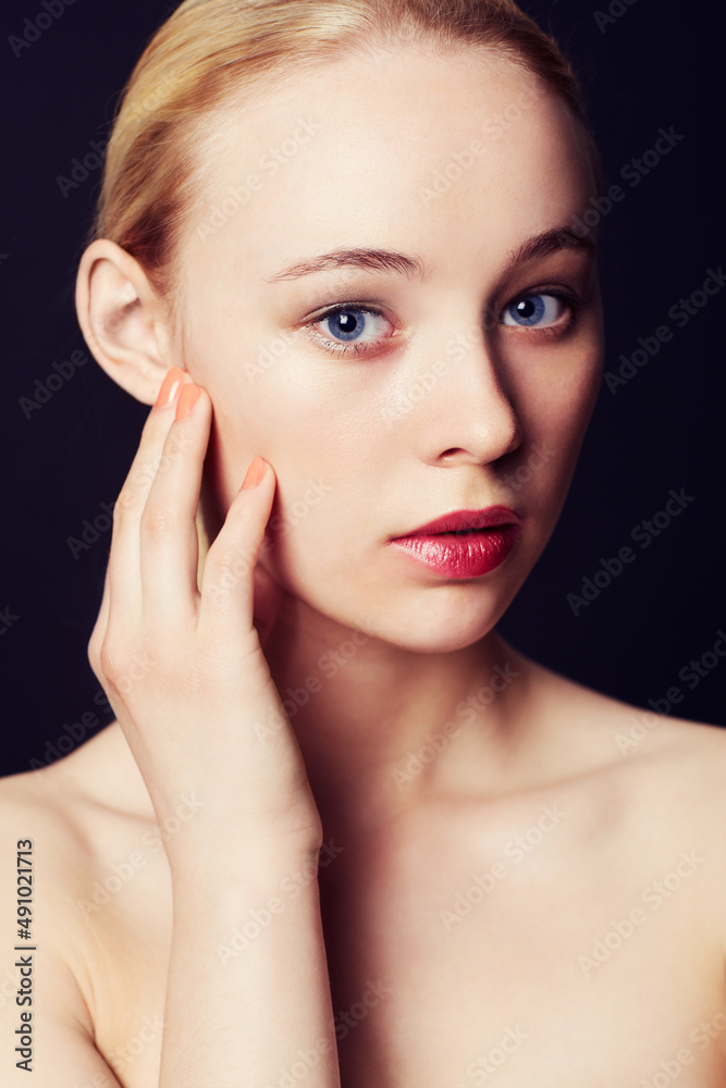 Caught in the cameras gaze. Beauty portrait of a young blond woman against a black background. Caught in the cameras gaze. Beauty portrait of a young blond woman against a black background.