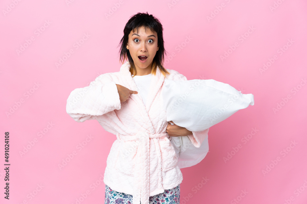 Young Uruguayan woman in pajamas over isolated pink background with surprise facial expression Young Uruguayan woman in pajamas over isolated pink background with surprise facial expression