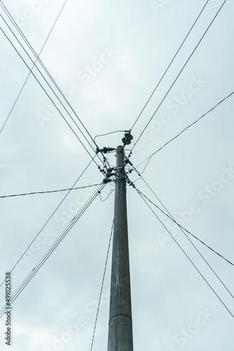 Street electric pole with many electrical wires and fiber optic cables