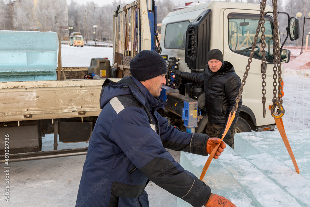 Portrait of fitters unloading ice blocks with truck crane Portrait of fitters unloading ice blocks with truck crane