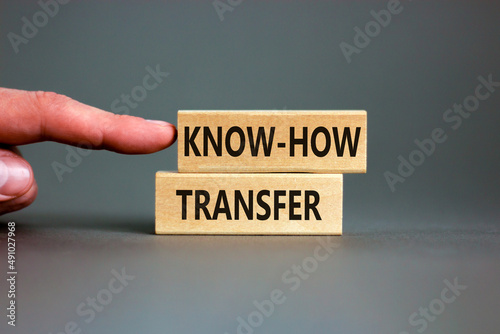 Know-how transfer symbol. Concept words Know-how transfer on wooden blocks on beautiful grey table grey background. Businessman hand. Copy space. Business innovation and know-how transfer concept.