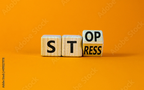 Stop stress and be health symbol. Turned the wooden cube and changed the concept words Stress to Stop. Beautiful orange background. Psychological business and stop stress concept. Copy space. photo