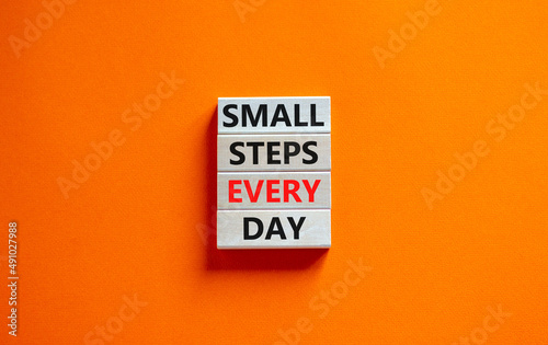 Small steps every day symbol. Concept words Small steps every day on wooden blocks. Beautiful orange table orange background. Small steps every day business concept. Copy space.