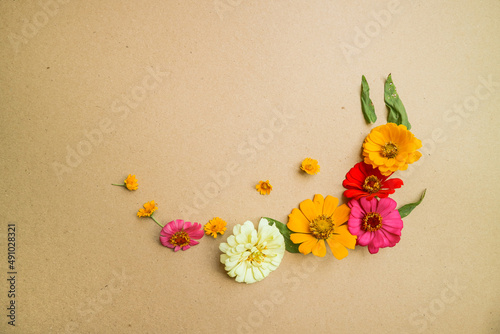Beautiful flower flat lay arrangement on brown background. Flat lay bouquet, top view, overhead, empty space for copied text.
