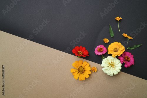 Beautiful flower flat lay arrangement on black and brown background. Flat lay bouquet, top view, overhead, empty space for copied text.