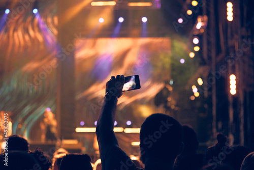 Person holding modern smartphone on a concert.