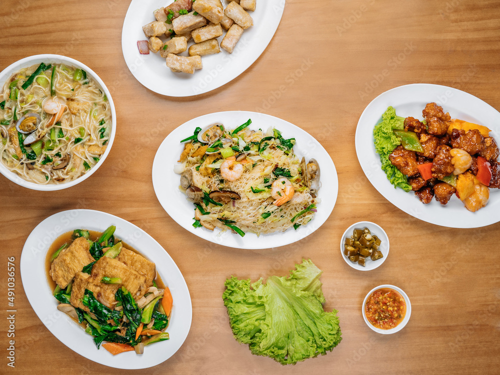 chinese seafood table Beancurd Kailan, Stir Fried yam, Xinghua Lor Mee, in a dish with chili sauce, and king's salad leaf top view on wooden background chinese seafood table Beancurd Kailan, Stir Fried yam, Xinghua Lor Mee, in a dish with chili sauce, and king's salad leaf top view on wooden background