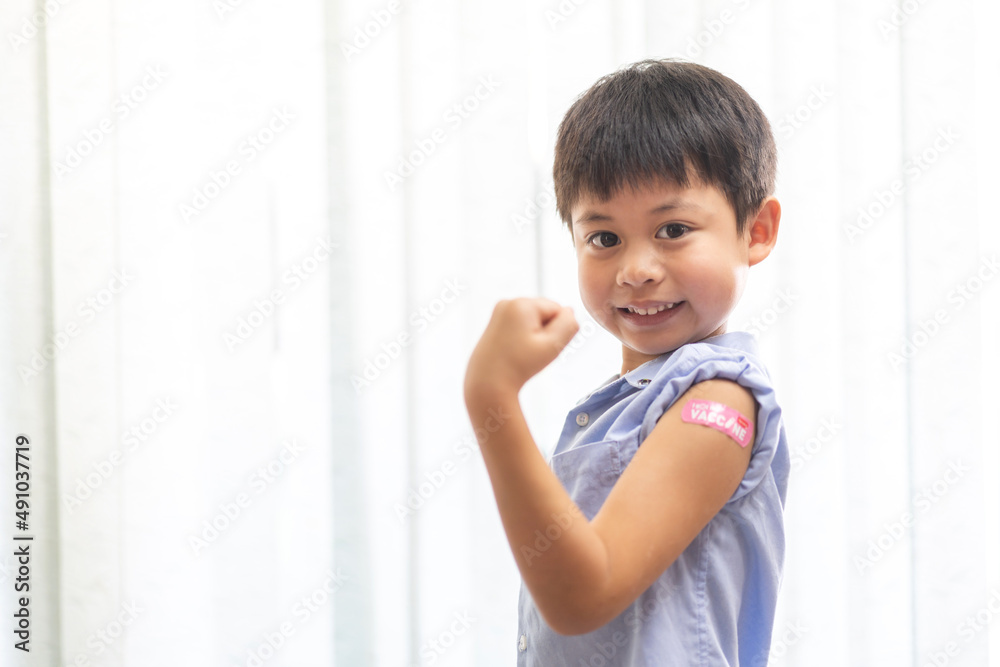 Portrait of happy smile vaccinated little asian kid boy children ages 5 to 11 years old posing show arm with medical plaster after Injection vaccine Covid-19 protection.coronavirus vaccination kid Portrait of happy smile vaccinated little asian kid boy children ages 5 to 11 years old posing show arm with medical plaster after Injection vaccine Covid-19 protection.coronavirus vaccination kid