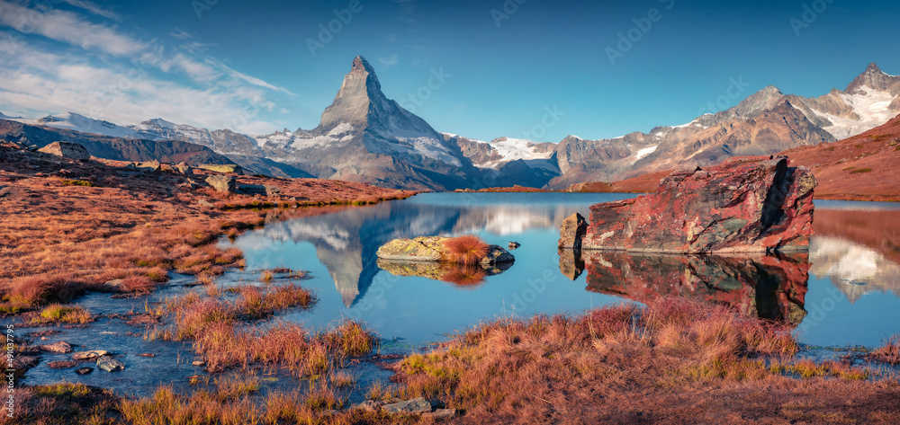 Panoramic morning view of Stellisee lake with Matterhorn/Cervino peak on background. Colorful autumn scene of Swiss Alps, Zermatt location, Switzerland, Europe. Beauty of nature concept background.