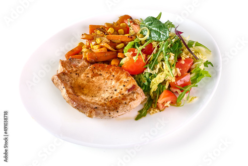 Grilled juicy pork steak with vegetable salad, close-up, isolated on white background.