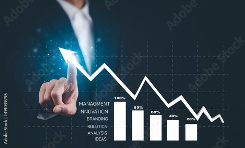 Businessman hand touching arrow virtual screen business graph on the black background, sales data analysis, Modern technology business people choose with finger analytical diagram with big data.