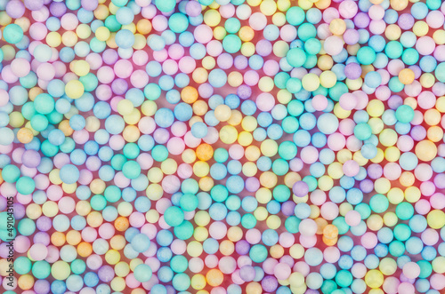 Foam beads of various colors brightly colored background.