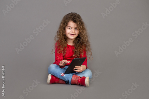 Happy Little Child Girl Using Digital Tablet, touch screen computer