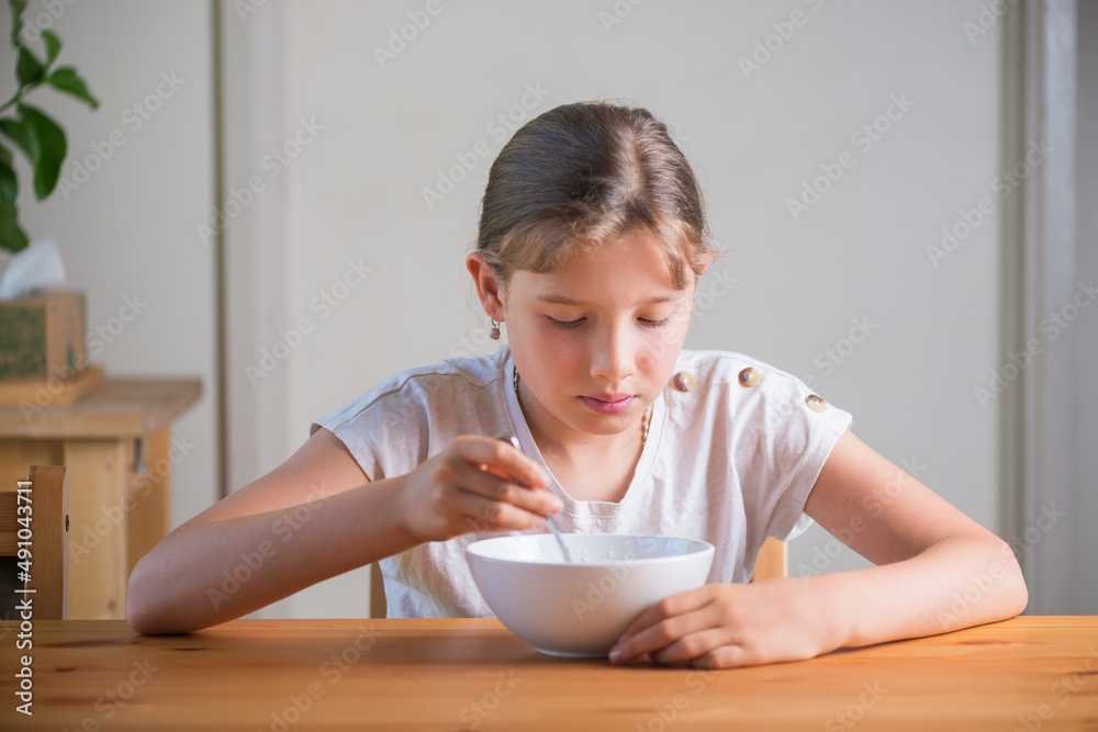Blonde teenage girl eating cereal for breakfast. Lifestyle portrait. Blonde teenage girl eating cereal for breakfast. Lifestyle portrait.