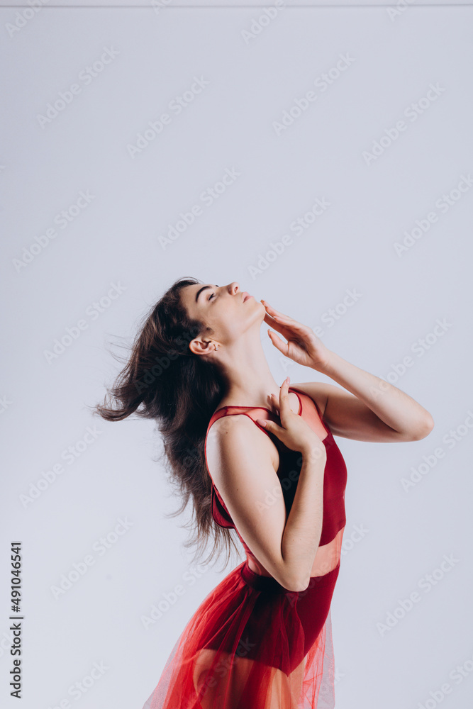 portrait of a beautiful ballerina in a red dress on a white background portrait of a beautiful ballerina in a red dress on a white background