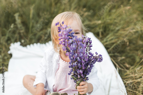 girl sitting on a blanket in a field of flowers