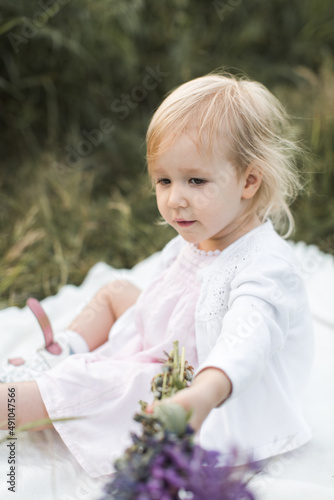 girl sitting on a blanket in a field of flowers