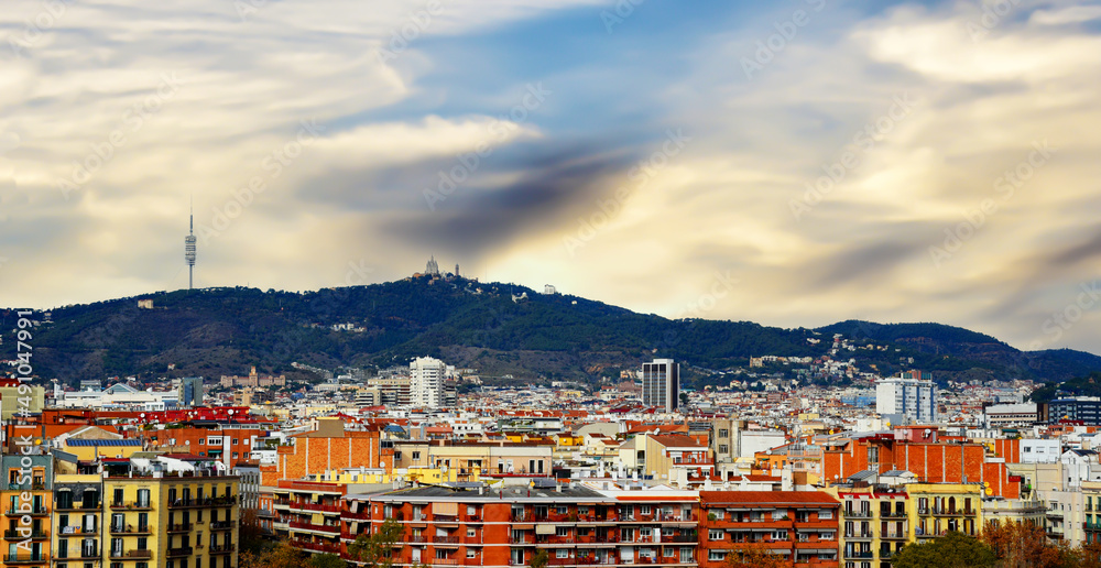 Panoramic aerial view of the city of Catalonia, Barcelona, Spain. Travel landscape. Roofs and facades of residential buildings. Panorama of the houses against the background of mountains.