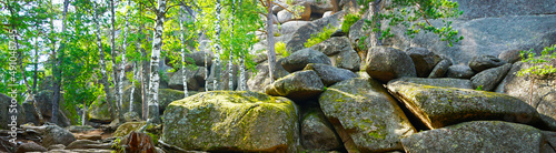 Huge stones covered with moss. Forest. Mountain. Landscape with rocks. Close-up. Nature background for design. Wide banner. Panoramic. National Park Krasnoyarsk Pillars. Siberia.