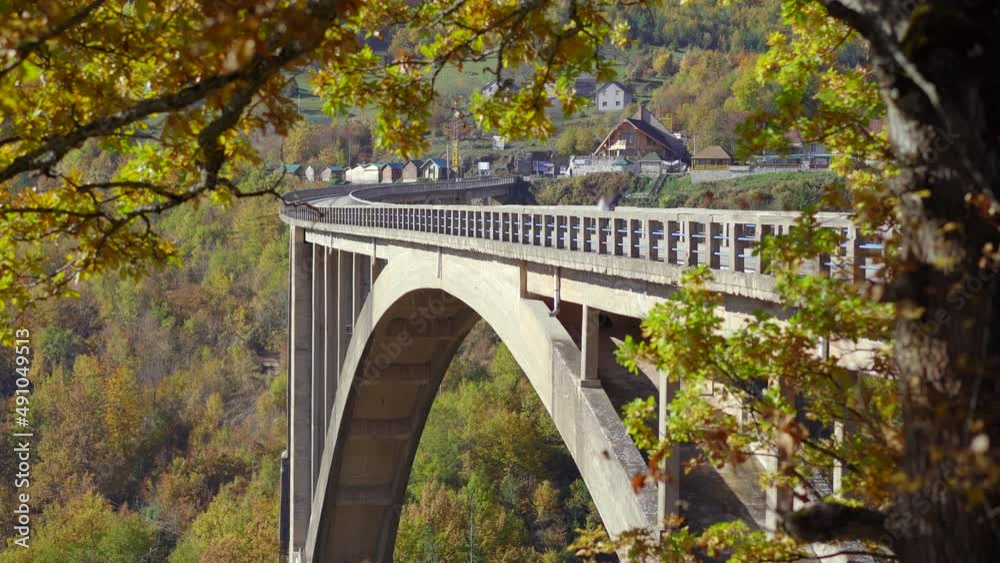 A handheld shot of the magnificent Djurdjevica Bridge over the Tara river canyon in the northern part of Montenegro. Shot in the fall season. Travel to Eastern Europe concept A handheld shot of the magnificent Djurdjevica Bridge over the Tara river canyon in the northern part of Montenegro. Shot in the fall season. Travel to Eastern Europe concept