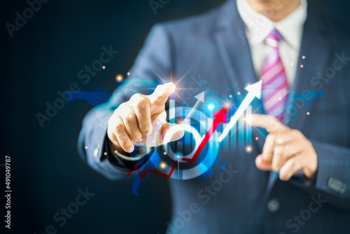 Businessman points an arrow graph of growth and financial network connection, analyzing data to improve sales to meet business investment goals. Technology in the Global Economy