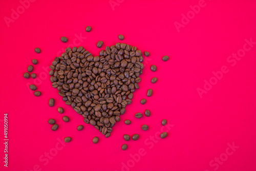 Heart shaped coffee beans on a crimson background