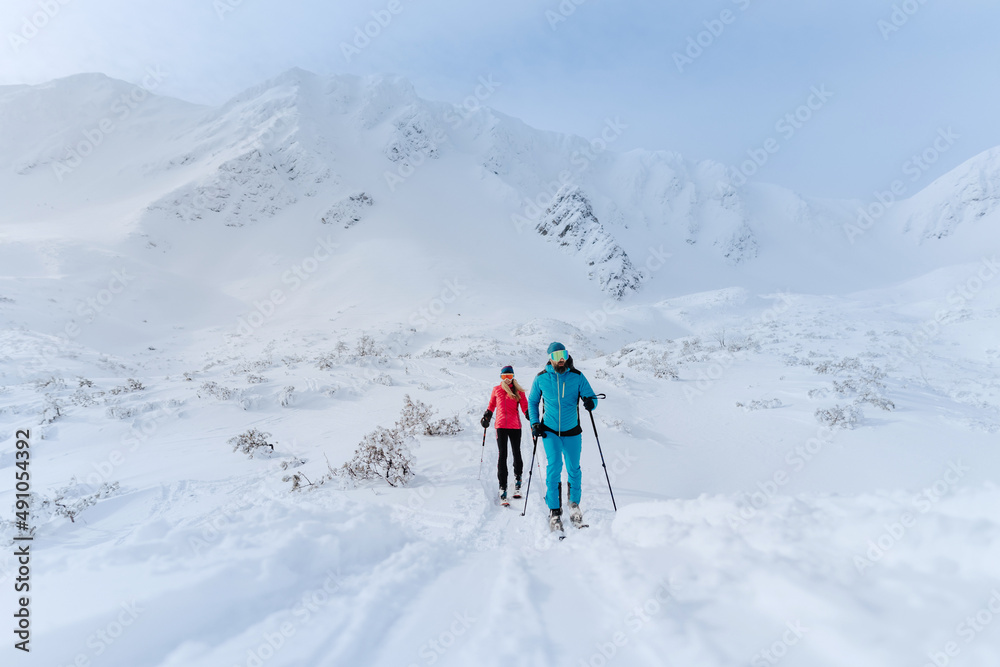 Front view of ski touring couple hiking up a mountain in the Low Tatras in Slovakia.
