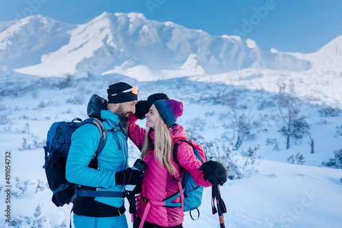 Ski touring couple in love taking break on the top of mountain in the Low Tatras in Slovakia.