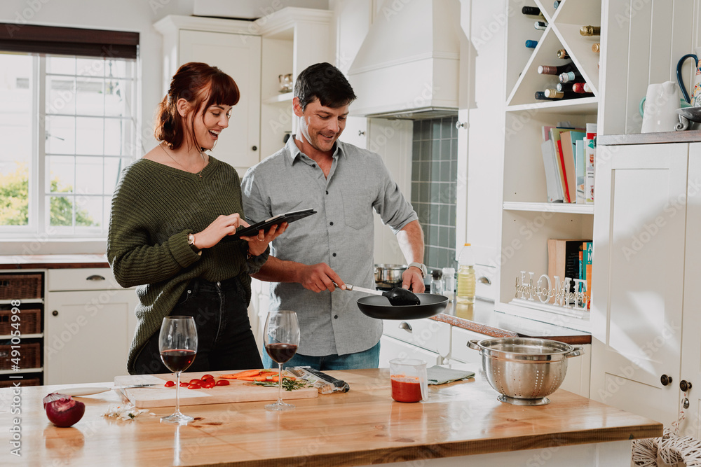Everything has to look perfect for our blog. Shot of a couple using a digital tablet while cooking at home.
