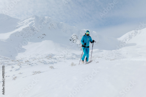 Male backcountry skier hiking to the summit of a snowy peak in the Low Tatras in Slovakia.