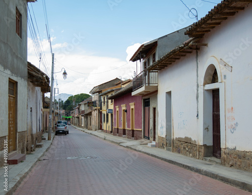 fotografia arquitectonica colonial de casas antiguas y estructuras, perspectiva de una calle con casas coloridas
