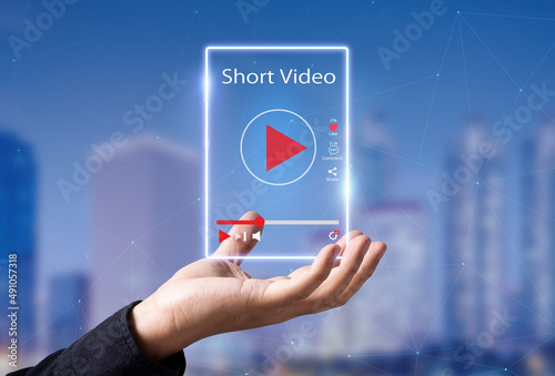 Short Video marketing concept.Man hands holding virtual short video player with blurred city as background