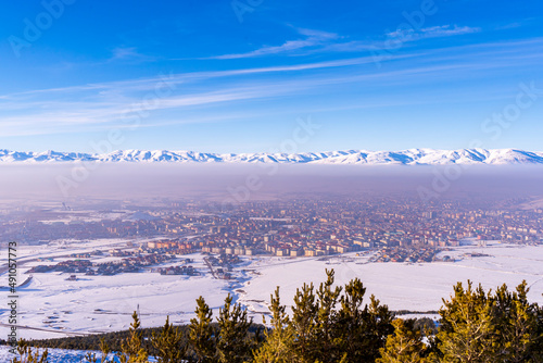 Ski slopes and Ski lifts. Small pine trees with snow. Mountain skiing and snowboarding. View of Erzurum city from Palandoken mountain © Birol