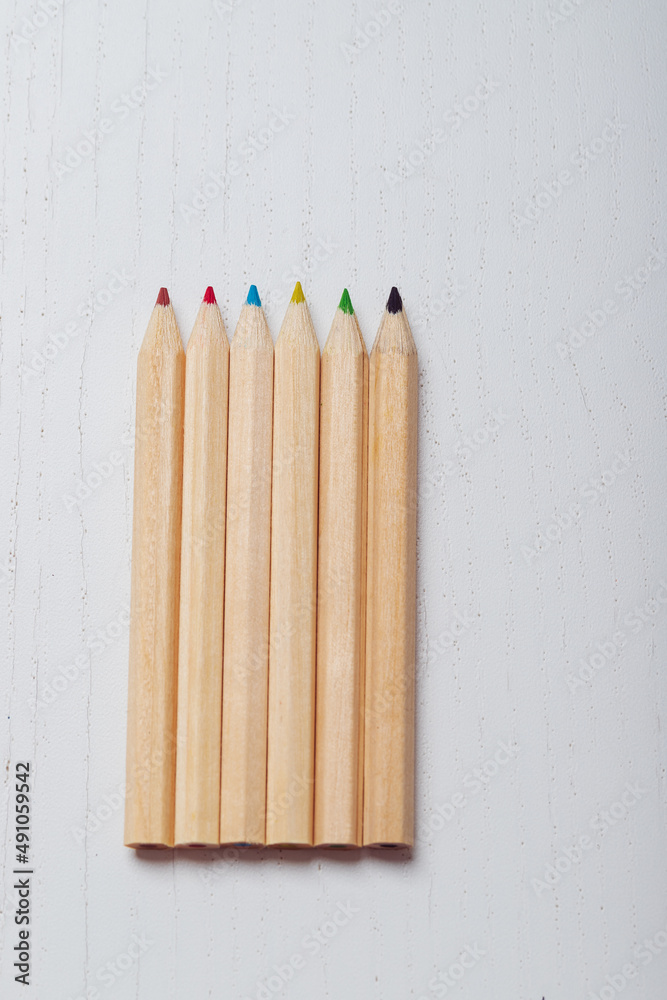 Fototapeta premium Wooden colored crayons on a white background.
