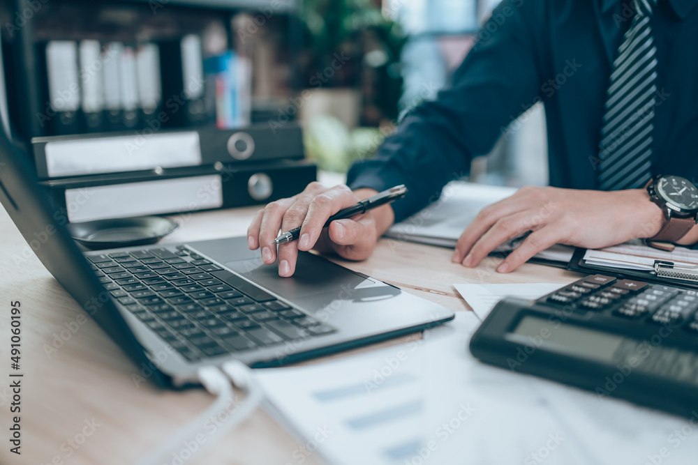 Accountant working on calculator to calculate company data, document and report on desk office. Accounting business concept. Accountant working on calculator to calculate company data, document and report on desk office. Accounting business concept.