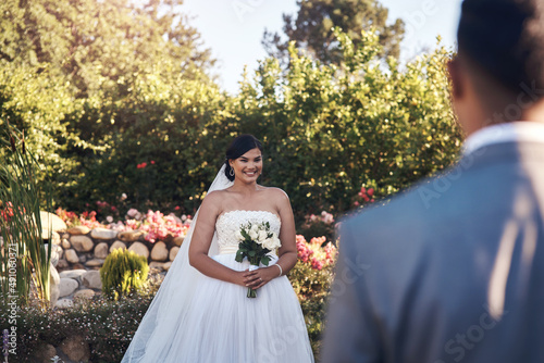 I still feel butterflies whenever hes around. Cropped shot of a happy bride looking at her groom. photo