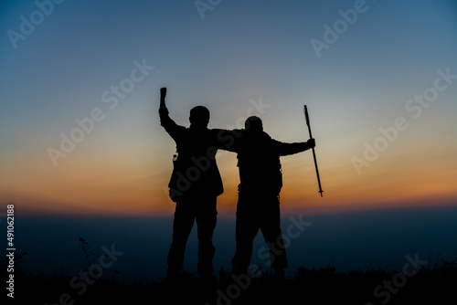 silhouette of backpackers standing in pairs on the mountain successful concept scene