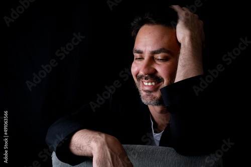 Portrait of a young, handsome, with shy expression, with black background