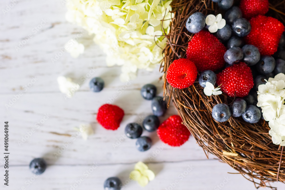 Ripe blueberries and Tibetan raspberries lie in a basket of vines Ripe blueberries and Tibetan raspberries lie in a basket of vines